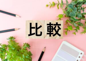 比較の文字とペンとメモ帳と植物