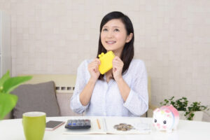 家計簿つけながら嬉しそうな女性